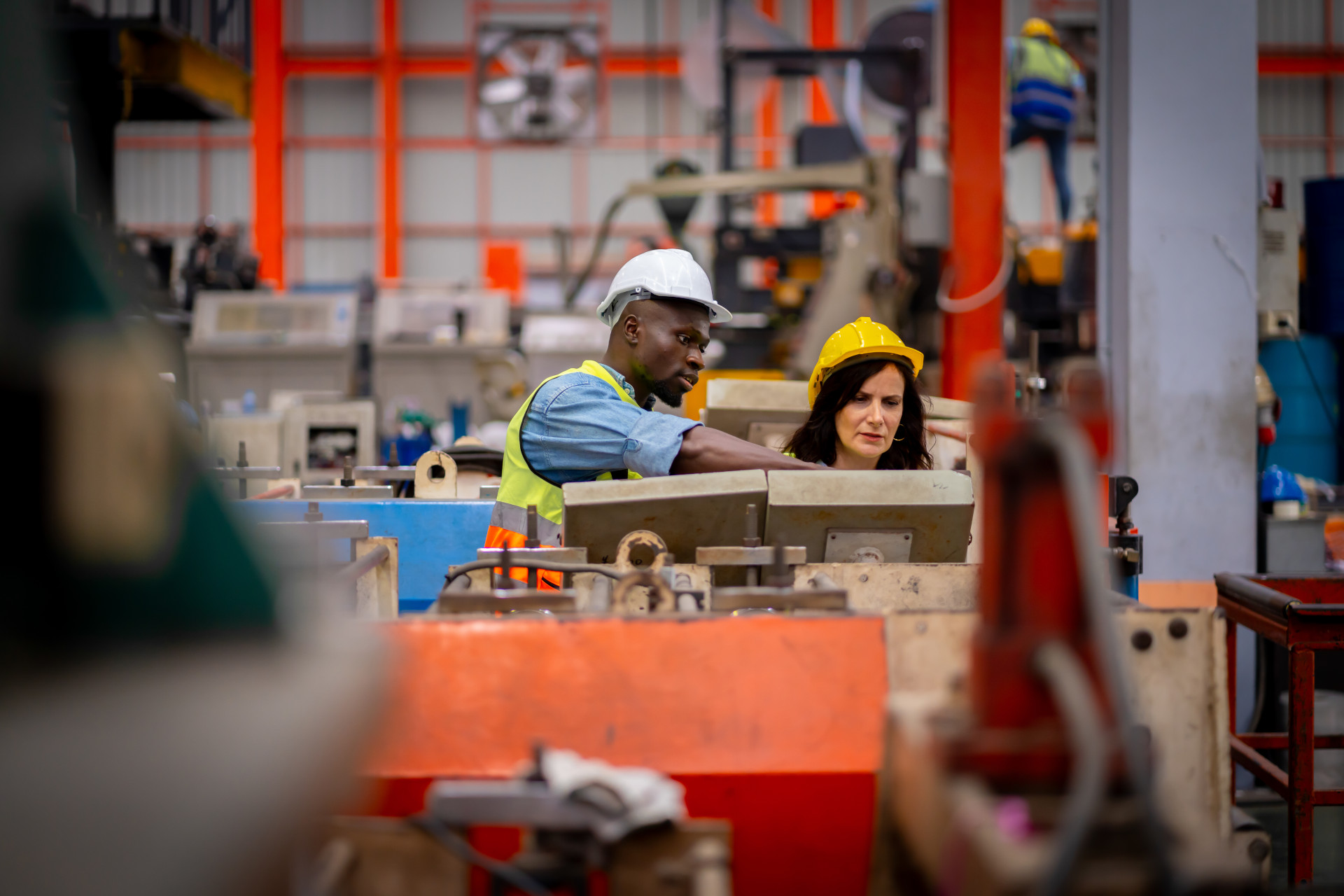 Team Of Young Male And Female Engineers In A Metal Sheet Factory